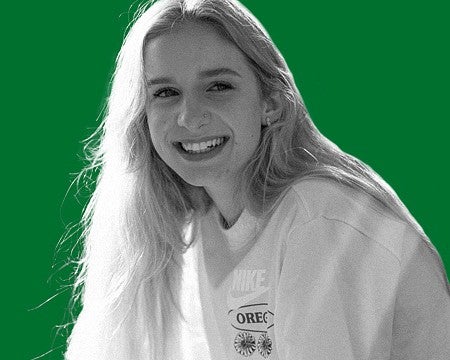 a greyscale image of a person smiling with a green background