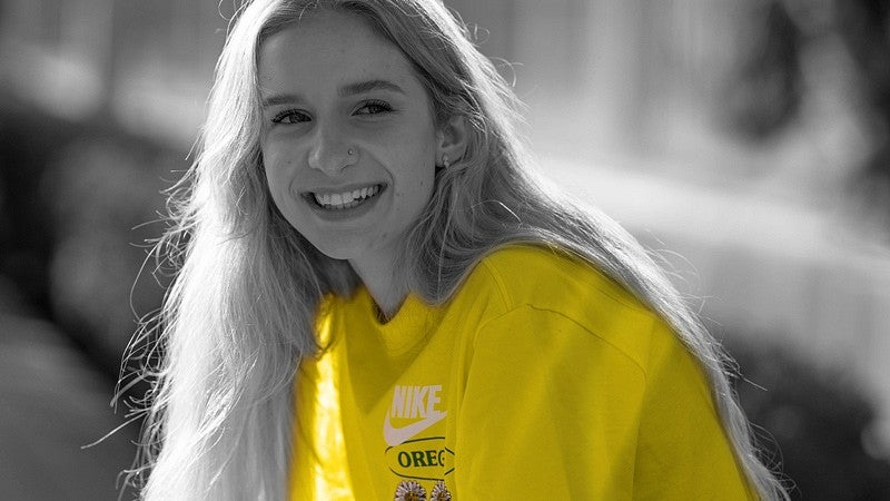 a person smiling in greyscale with yellow shift