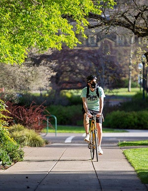 Student riding bike on campus