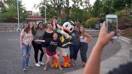 students posing for a photo with the oregon duck