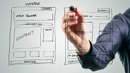 Man drawing a website wireframe on a transparant white board