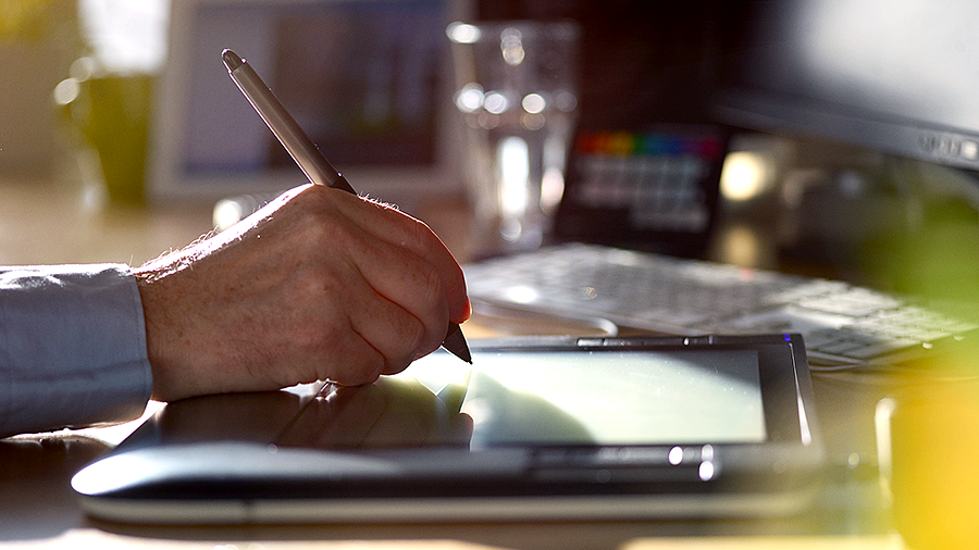 a person using a digital pen to draw on an ipad