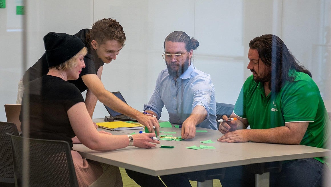 Four students brainstomring around a table