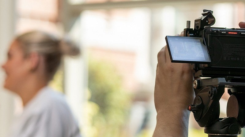 videographer filming a female student