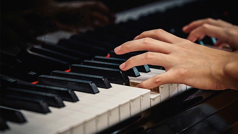 the hands of a person playing piano