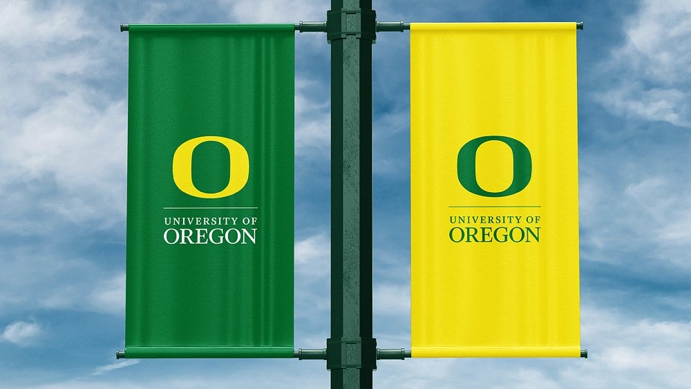 green and yellow pole banners displaying the O and the words University of Oregon