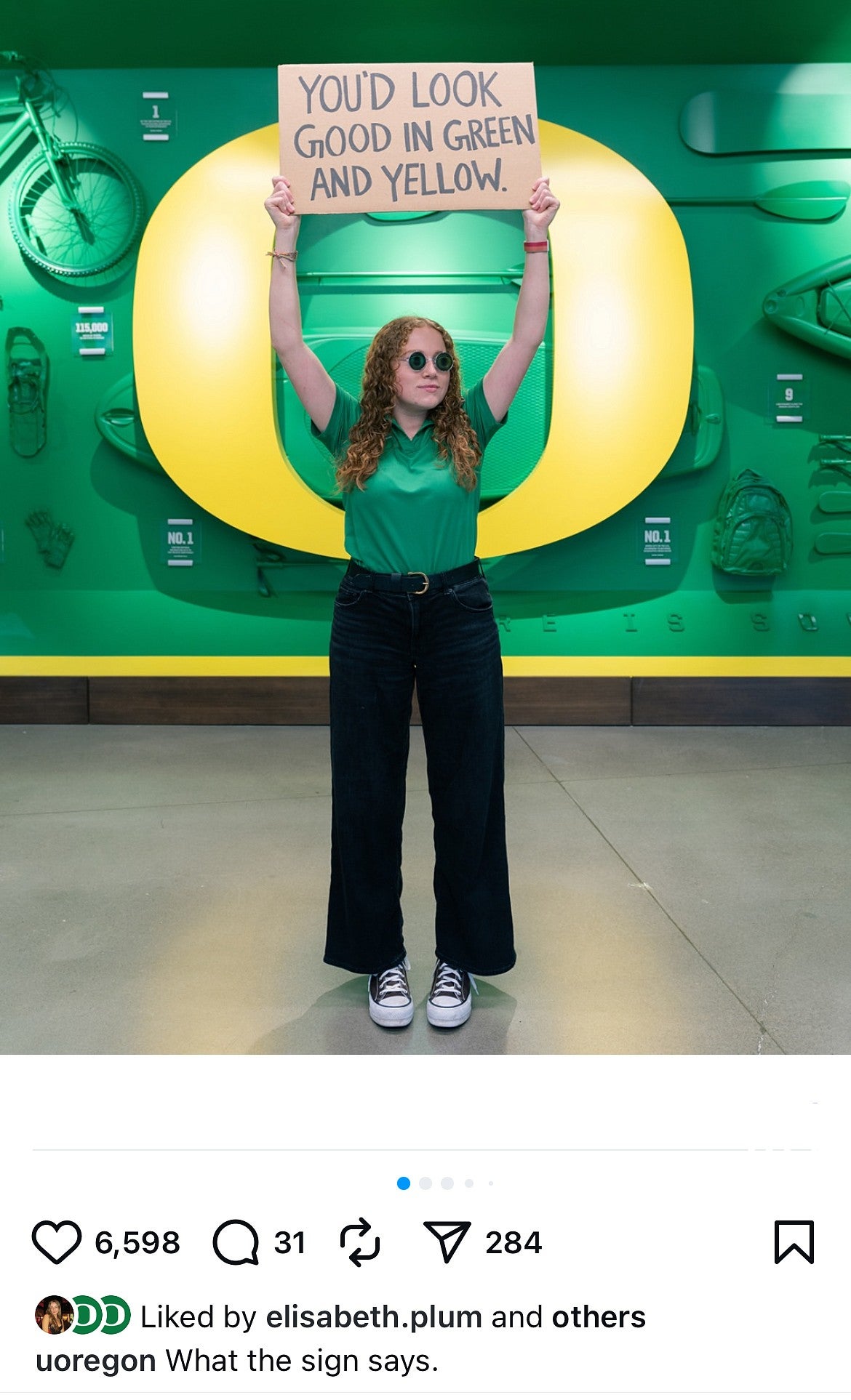 Student holding sign in front of a big yellow O