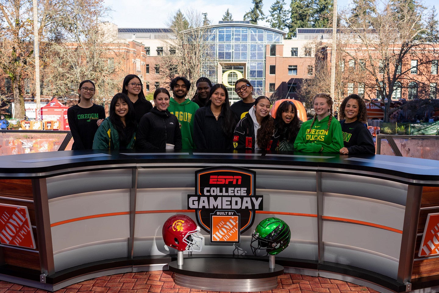 A group of people standing behind the ESPN College GameDay desk