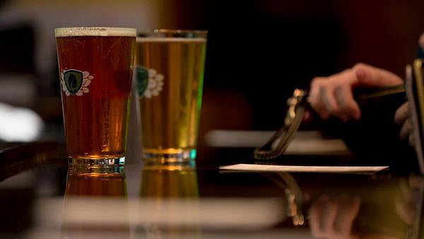 two pints of beer at a bar