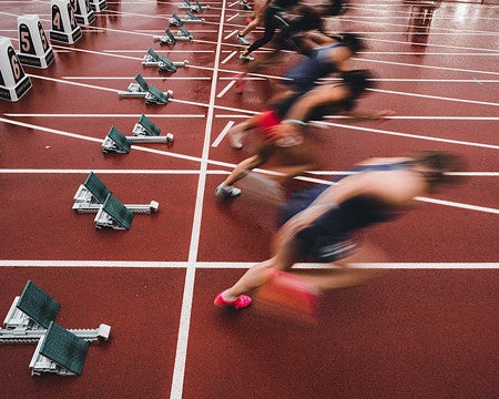 blurred sprinters leaving the starting block