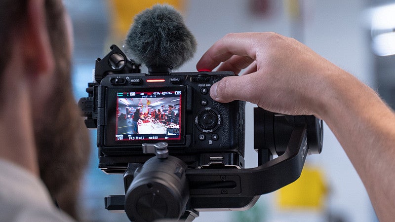 videographer recording behind their digital camera