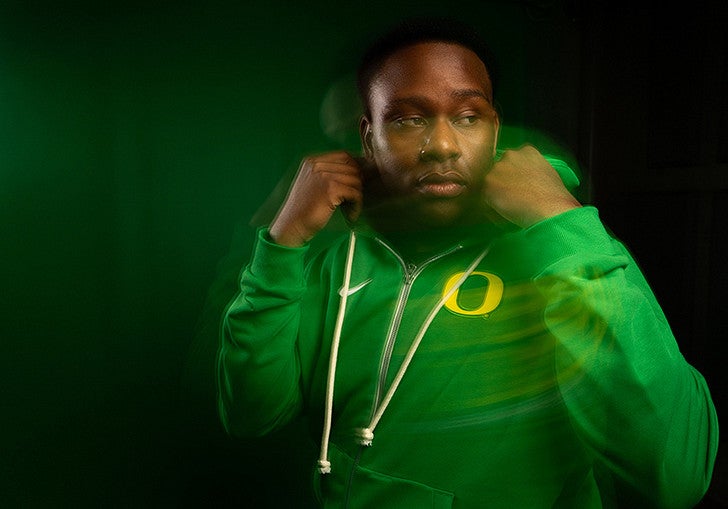 a man wearing a green Oregon hoodie in a motion blur sytle