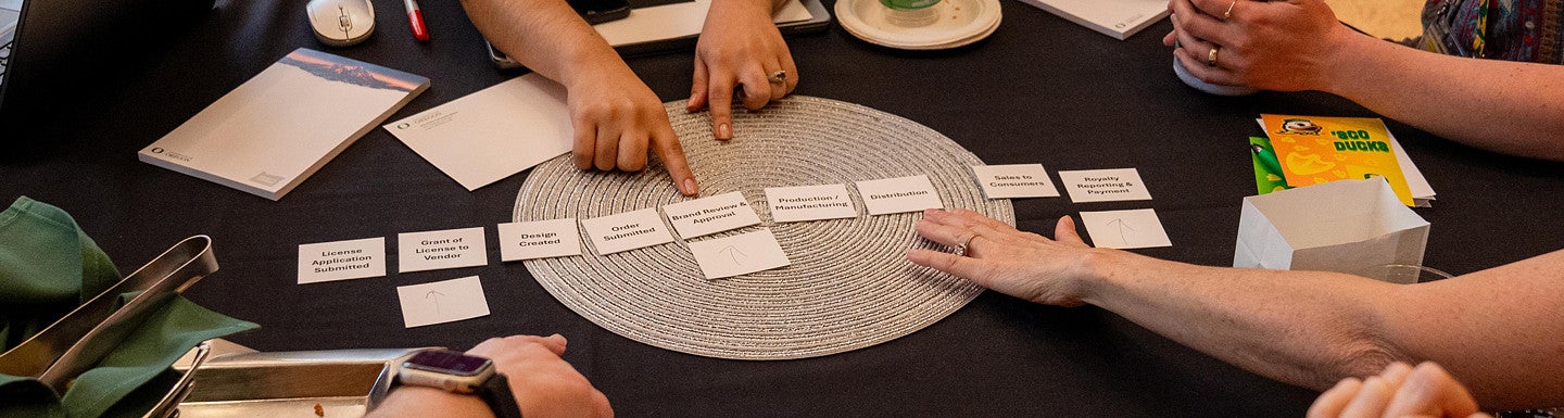 hands ordering sheets of paper representing steps of the licensing processes