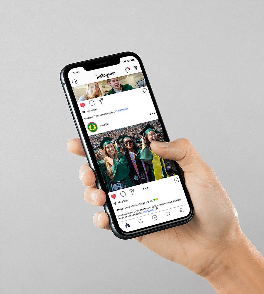 hand holding iphone with social media posts of graduation