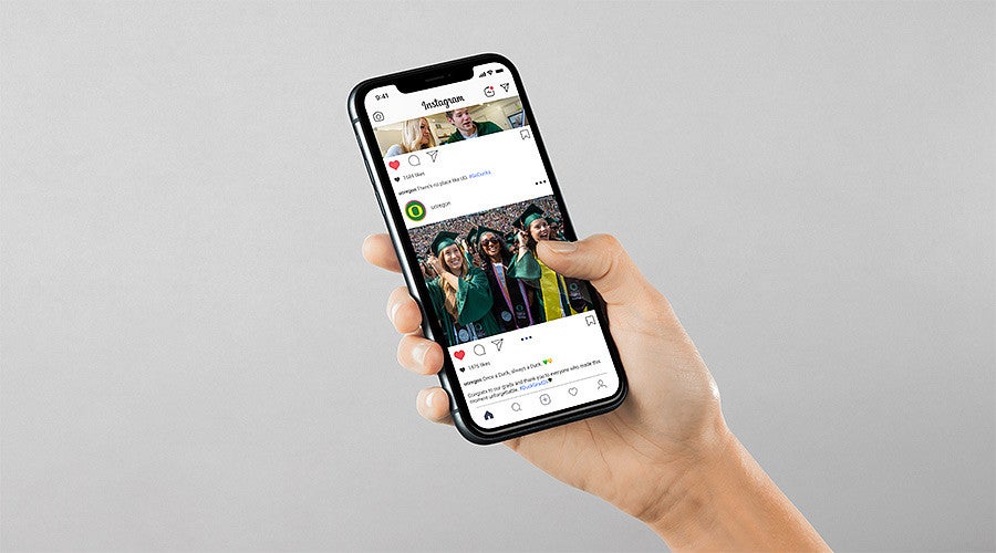 hand holding iphone with social media posts of graduation