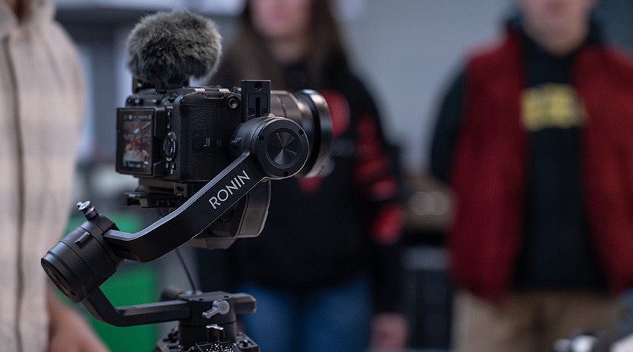 video camera with students blurred in the background