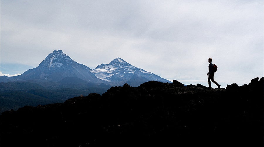 Silhouette of a person hiking a mountain ridge 