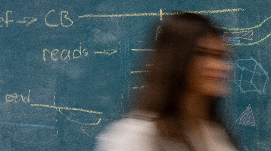 motion blur of a woman passing by a chalkboard