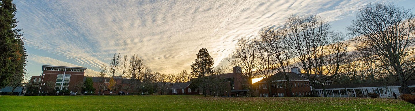 buildings on the UO campus in Eugene with clouds lit up by the sunset