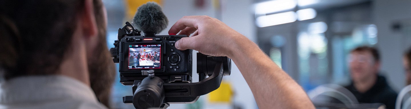 a videographer recording from behind the digital camera