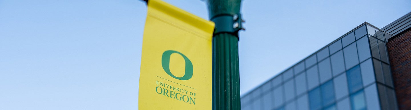 yellow pole banner with green university of oregon primary mark