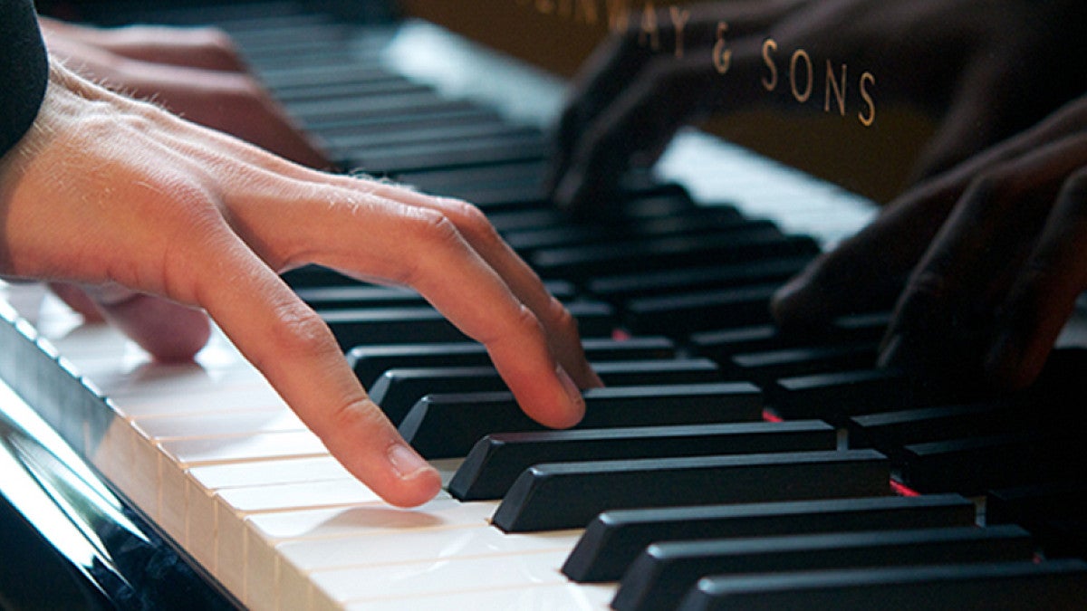 Hands playing a piano