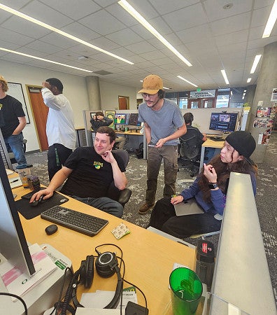 Students and staff looking at a computer together